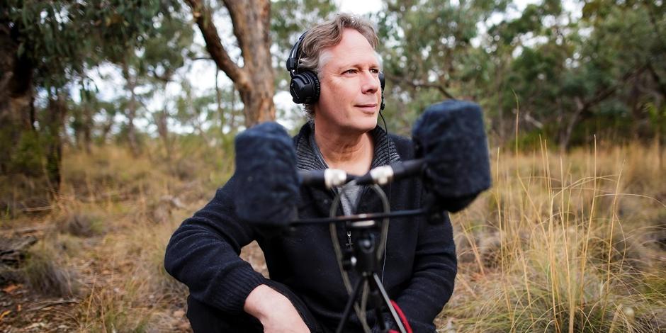 Andrew Skeoch crouched down next to his equipment in the field