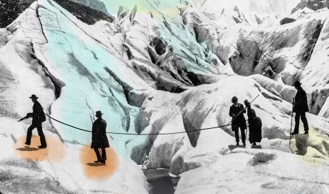 A vintage shot of early mountain climbers helping each other cross a crevasse